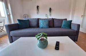 uma sala de estar com um sofá e um controlo remoto em Apartamentos Jardim do Morro em Vila Nova de Gaia