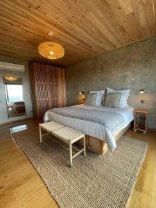 a bedroom with a large bed and a wooden ceiling at Casa do Alecrim in São Roque do Pico