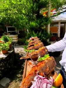 a pile of food on a wooden table with a person at Qafqaz Fountain Villa in Gabala
