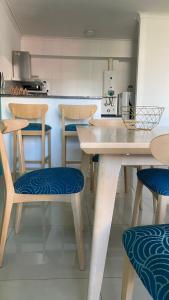 cocina con sillas de madera, mesa y barra en Agustín I Apart en Paraná