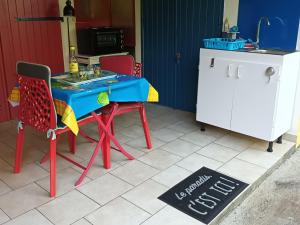 a table and chairs in a kitchen with a sign on the floor at Passion Caraïbes in Saint-Claude