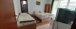 a room with two beds and a television in it at Apartments Trajceski in Ohrid