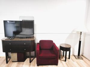 a living room with a chair and a television at Hotel Sigma in Val-dʼOr