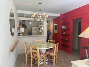 a dining room with a table and chairs and red walls at Playa, confort y naturaleza todo el año in Costa del Este +15 photos