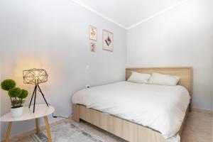 a white bedroom with a bed and a table at Luxury Central Apartment in Xanthi