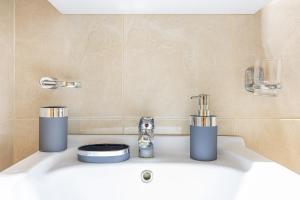 a bathroom counter with a sink with a faucet at Luxury Central Apartment in Xanthi +22 photos