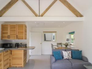 a living room with a couch and a kitchen at Chapel Cottage in Pershore