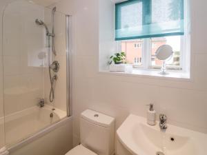 a bathroom with a toilet and a sink and a window at Chapel Cottage in Pershore +13 photos