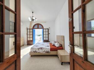 a bedroom with a bed and an open door at Maison Karima in Djerba