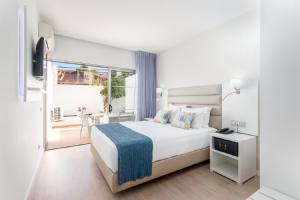 a white bedroom with a bed and a balcony at Carvi Beach Hotel in Lagos +37 photos