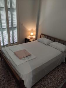 a bedroom with a large bed with white sheets and pillows at Lemon Apartment near to Pireaus Port in Piraeus