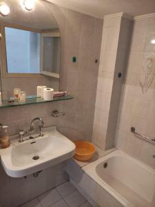 La salle de bains est pourvue d'un lavabo, d'une baignoire et de toilettes. dans l'établissement Lemon Apartment near to Pireaus Port, au Pirée