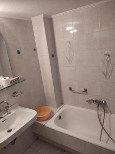 La salle de bains est pourvue d'une baignoire blanche et d'un lavabo. dans l'établissement Lemon Apartment near to Pireaus Port, au Pirée