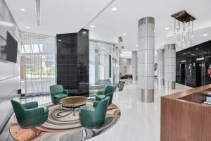 a lobby with green chairs and a table at Modern & Charming Apt With Rooftop @pentagon City in Arlington +28 photos