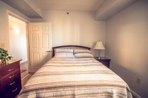 1 dormitorio con 1 cama con manta a rayas en Water Street Retreat 12 en Wilmington