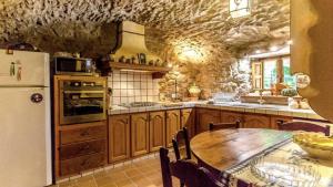 cocina con mesa de madera y nevera blanca en CAL CARRETER en Foixá