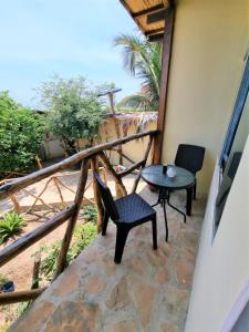 un patio con 2 sedie e un tavolo sul balcone di Bright Bungalows - Frente al Mar a Zorritos