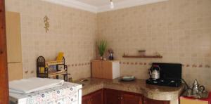 uma cozinha com uma bancada e um frigorífico em Duplex Malika em El Jadida