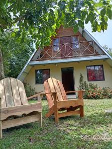 zwei Holzstühle vor einem Haus in der Unterkunft Hostal claire in El Quije