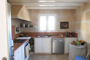a kitchen with white cabinets and a sink and a window at FINCA SON SEGUI in Alaior