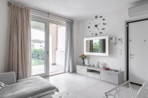 Sala de estar blanca con reloj en la pared en Lakefront Nuova Riva - by Host4U, en Padenghe sul Garda