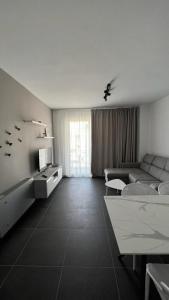 ein Wohnzimmer mit einem Sofa und einem TV in der Unterkunft Sole apartments in Shëngjin