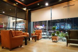 um lobby com cadeiras e mesas em frente a uma loja em Lilac Hotel em Erbil