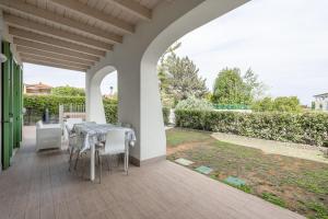 un patio con mesa y sillas y un jardín en Lakefront Nuova Riva - by Host4U, en Padenghe sul Garda
