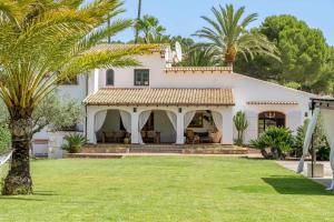 una casa blanca con palmeras en el patio en Villa Enri Dreamy Vacation Home Pool Jacuzzi, en Parcent