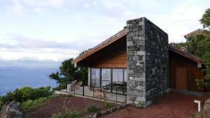 a house on a hill overlooking the water at Lava Homes in Santo Amaro