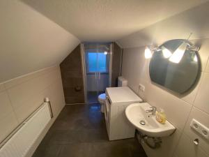 a bathroom with a sink and a toilet and a mirror at Gemütliche Ferien- und Monteurwohnung in Stadtnähe in Oldenburg
