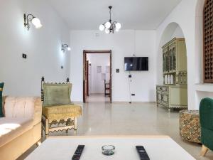 a living room with a couch and a chair at Maison Karima in Djerba