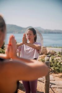 7Pines Resort Ibiza, part of Destination by Hyatt في سان خوسيه: امرأة تصفق بيديها امام الرجل