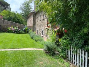 een stenen huis met een wit hek in een tuin bij CAL CARRETER in Foixá