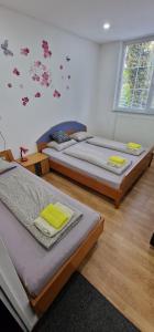 a bedroom with two beds and a wall with butterflies at Apartman MURKO P-2 