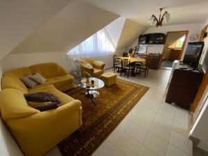 a living room with a yellow couch and a table at Varga Apartman in Balatonberény