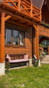 un banco sentado en el porche de una casa en Садиба "Маланка", en Mykulychyn