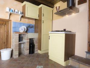 a kitchen with yellow cabinets and a brick fireplace at Antica Dimora San Girolamo in Licata +61 photos