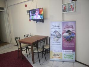 a dining room with a table and a tv at Hotel Efe in Trabzon