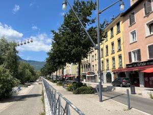 une rue de la ville avec une clôture, des bâtiments et une voiture dans l'établissement Charmant appartement 2 pièces au Centre ville, à Grenoble
