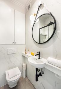 a white bathroom with a sink and a mirror at Metro Ratusz Arsenał Modern Studio in Warsaw