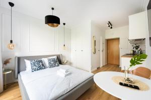 a small apartment with a bed and a table at Metro Ratusz Arsenał Modern Studio in Warsaw
