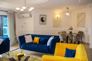 a living room with a blue couch and a table at Residence Le Carat Bonapriso in Douala