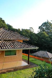 una casa con techo en la parte superior de un patio en Recanto dos Beija flores, Chalé Lantana c en Monte Alegre do Sul