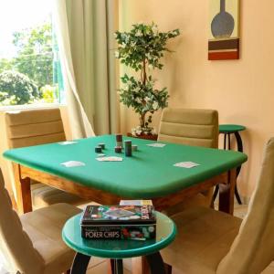 uma mesa verde numa sala de estar com cadeiras em Recanto dos Beija flores, Chalé Lantana c em Monte Alegre do Sul