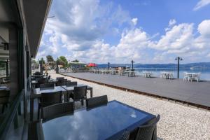 a patio with tables and chairs and the water at Özkum Tesisleri in Sapanca