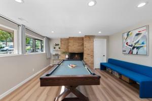 a living room with a pool table and a blue couch at Stylish spacious home with AC downtown Bellevue in Bellevue