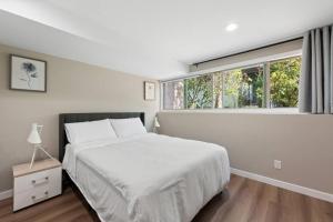 a bedroom with a white bed and a large window at Stylish spacious home with AC downtown Bellevue in Bellevue