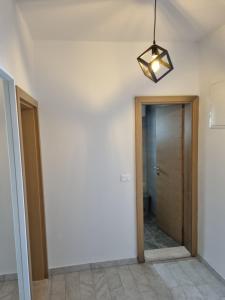 a hallway with a door and a light fixture at Apartmani Dalmatinka in Metajna