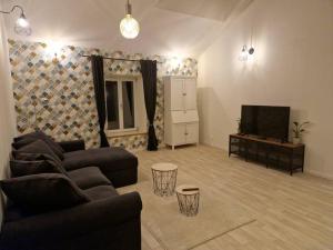 ein Wohnzimmer mit einem Sofa und einem Flachbild-TV in der Unterkunft Gîte de l'étoile, 6 pers. spacieux avec extérieur 